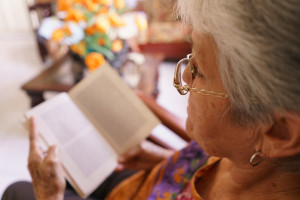 old-lady-reading-book-on-armchair-in-hospice-2021-08-26-15-46-11-utc.